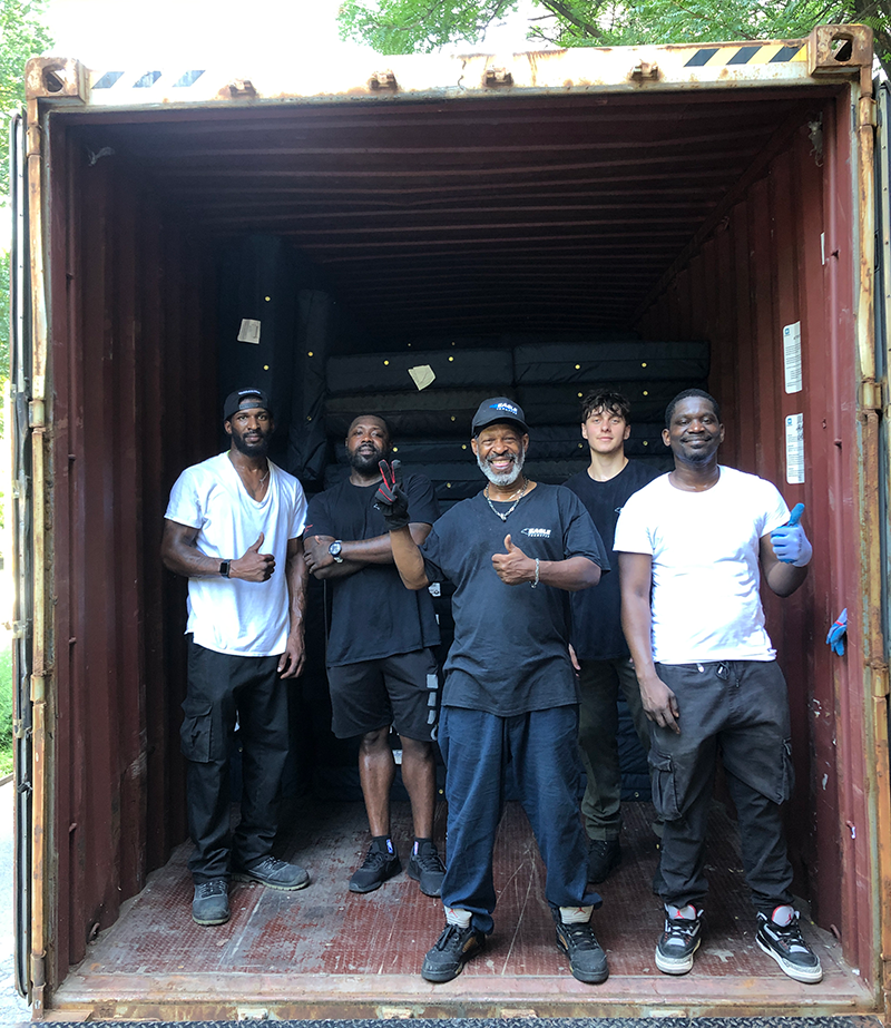 A work crew stands at the entrance to a cargo container
