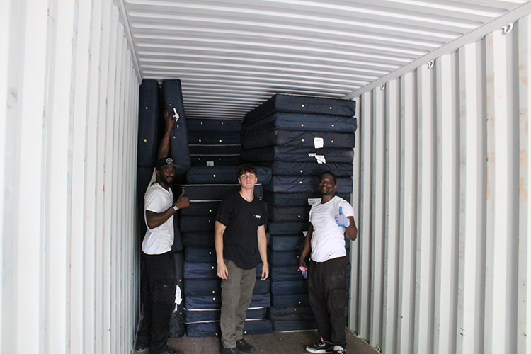 Three IRN crew members load mattresses into a truck. This shipment is scheduled for Ukraine.