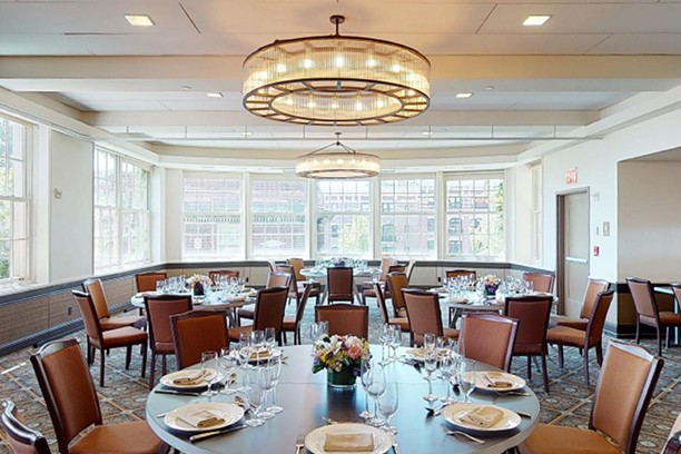 Faculty House set up for an event with table settings and a chandelier overhead