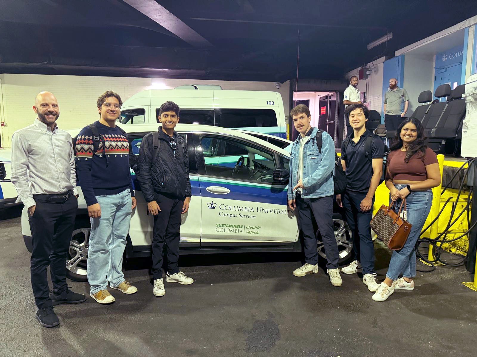 The Office of Sustainability's Dan Allalemdjian with members of EVO pose with a Columbia electric vehicle.