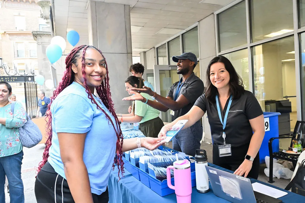 Students and staff at an information table during Housing Check-In