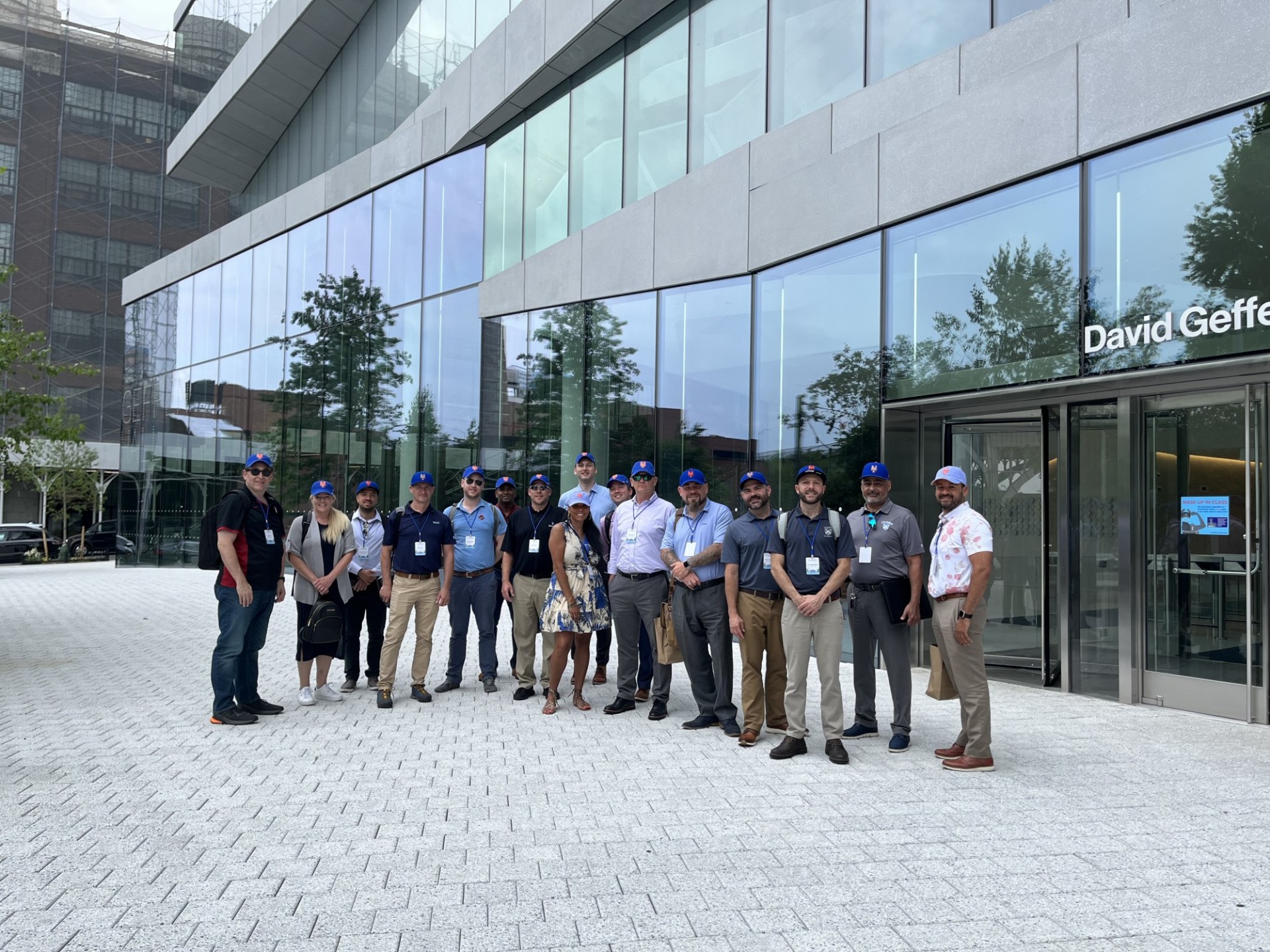 The group stands outside of David Geffen Hall at the Manhattanville Campus