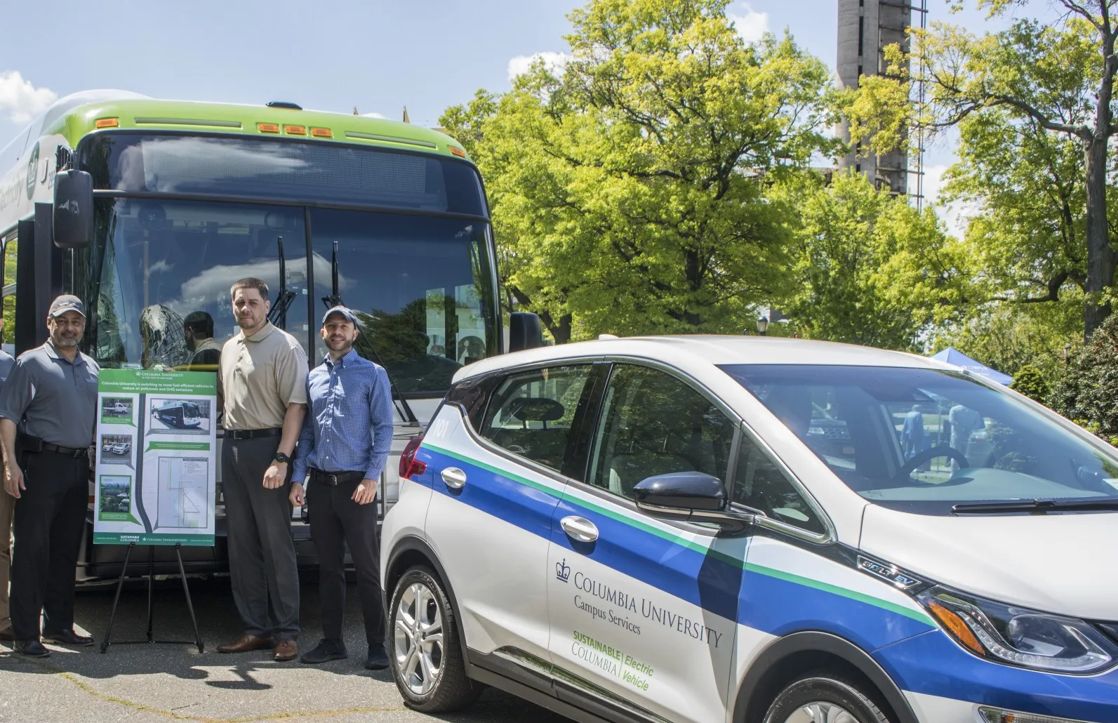 Mike Pagan, David Ramos, and Dan Allalemdjian stand in front of Columbia vehicles at trade show in Queens