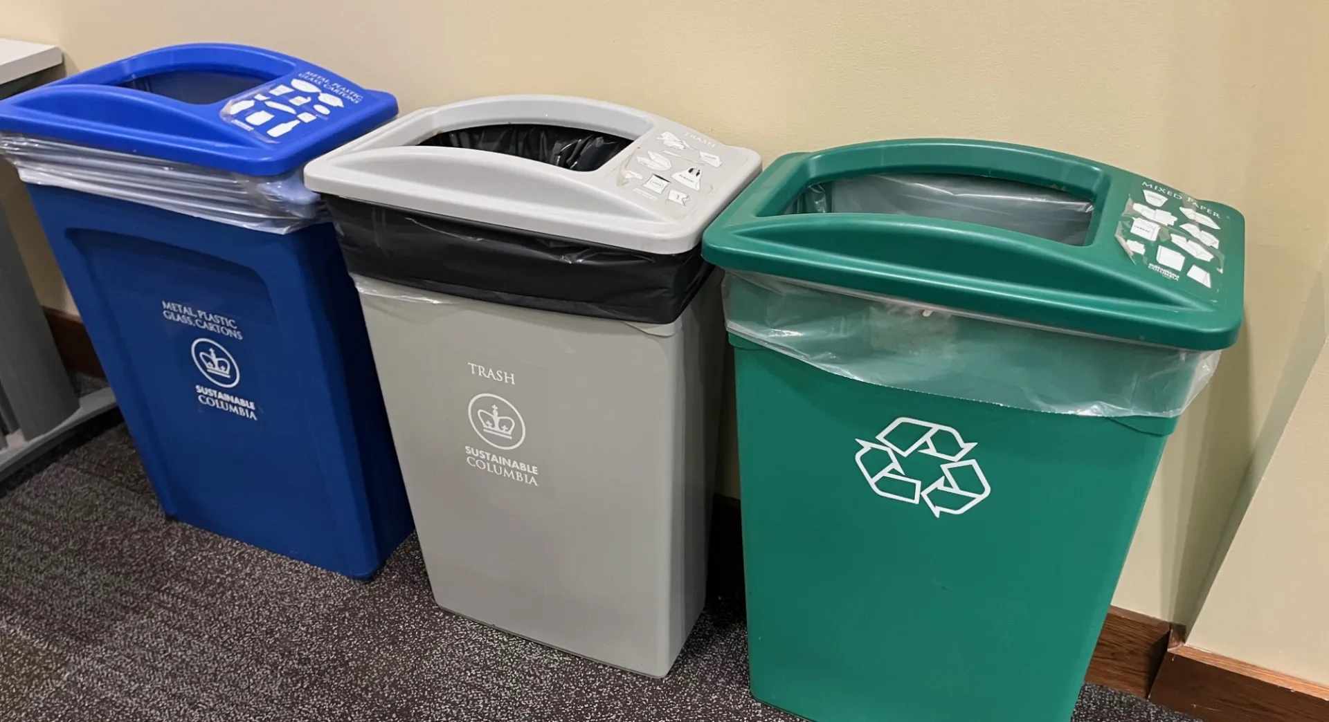 Waste and recycling bins in the hallway of the residence hall